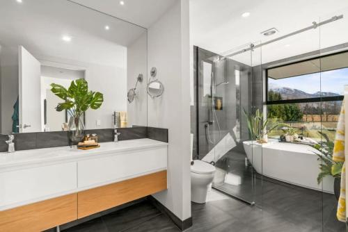 瓦纳卡Wanaka Luxury on Sutdholme的带浴缸、卫生间和盥洗盆的浴室