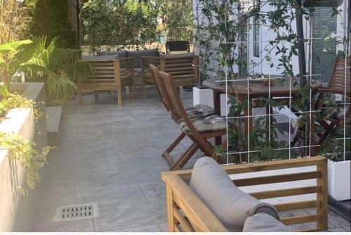伊佐拉Apartments Artemus Karliva的庭院配有桌椅、桌子和椅子。