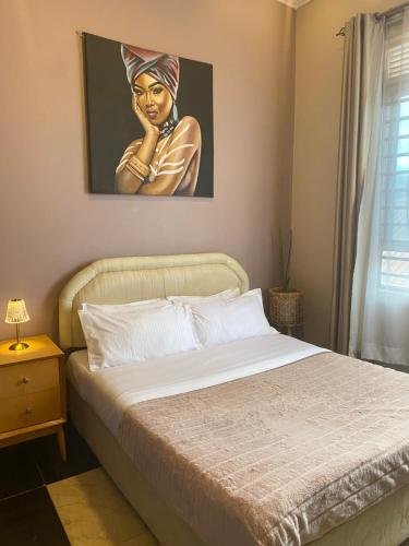 坎帕拉Casa del Court的卧室配有一张带女性绘画的床
