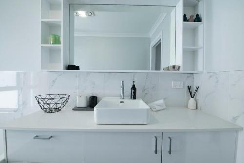 达博Cosy Retreat on Naman - Private & Convenient的白色的浴室设有水槽和镜子