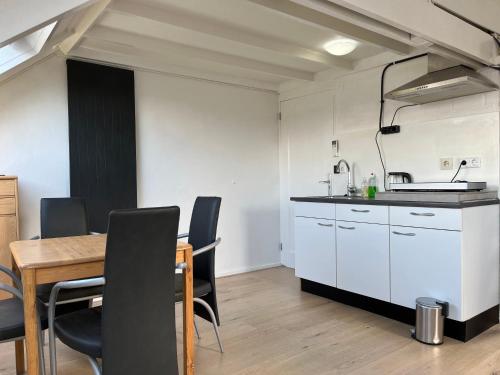 奈梅亨Studio met eigen badkamer en eigen keuken的厨房以及带桌椅的用餐室。