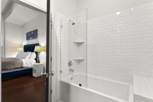 新奥尔良Modern pristine stunning 2BD Garden District Apt的带淋浴的浴室和客房内的一张床