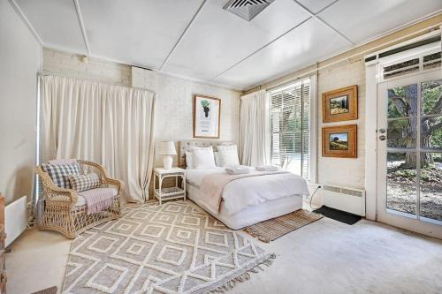 奥兰治The Garden Flat - Mayfield Vineyard Orange的卧室配有床、椅子和窗户。