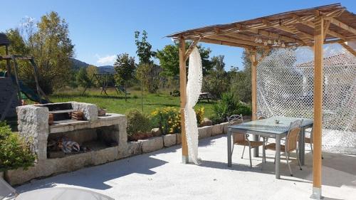 Petreto-BicchisanoVilla Piazzola的庭院设有桌子和石头壁炉。