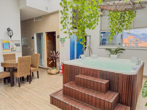 麦德林Hotel Bolivariana Plaza Medellin的配有桌椅的客房内的热水浴池