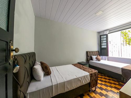 贝伦Hotel Filha do Cacique的一间卧室设有两张床和窗户。