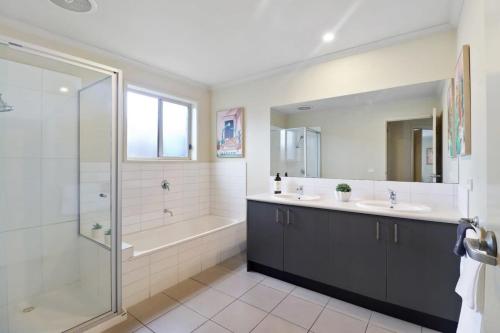 吉朗Reconnect on Daly I Epworth and Deakin的浴室配有2个盥洗盆、淋浴和浴缸。