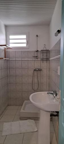 勒罗贝尔Villa Léïna的白色的浴室设有水槽和窗户。