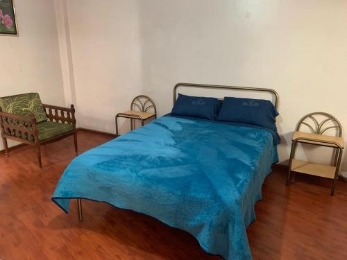 昆卡Hospedaje Fenix的一间卧室配有蓝色的床和两把椅子