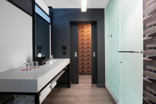 麦卡伦Aloft McAllen的一间带水槽和镜子的浴室