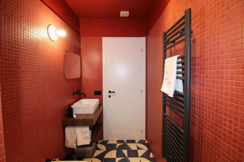 陶尔米纳C’est la vie TAORMINA的一间带红色墙壁和白色门的浴室