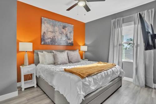 圣地亚哥Professionals-Restaurants-FastWiFi-A C-Desk- Pets的一间卧室配有一张橙色墙壁的床