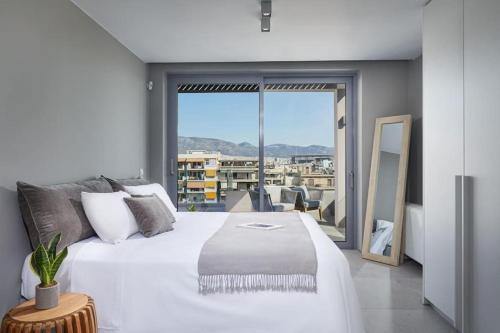雅典CW Athens Riviera Suite的一间带一张白色大床的卧室和一个阳台