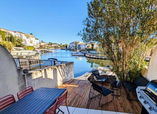 艾格-莫尔特Belle marina avec ponton et piscine collective的享有河流美景,配有桌椅