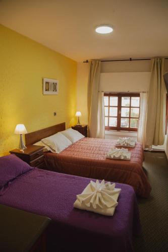 埃斯克尔HOSTERIA AKINO的酒店客房设有两张床和窗户。