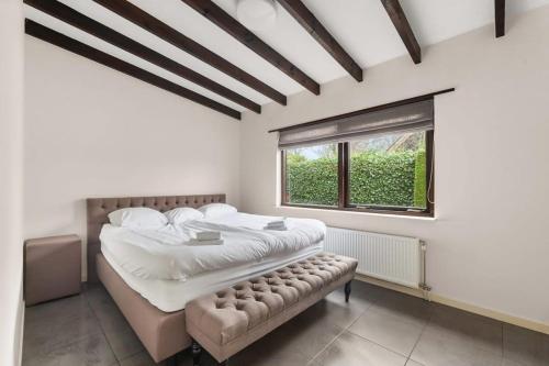 东卡佩勒Hello Zeeland - Villa Park Reygersbergh 11的一间卧室设有一张大床和一个窗户。