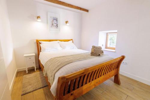 CessenonLa Loubière - Gîte的一间卧室配有一张木床和木凳