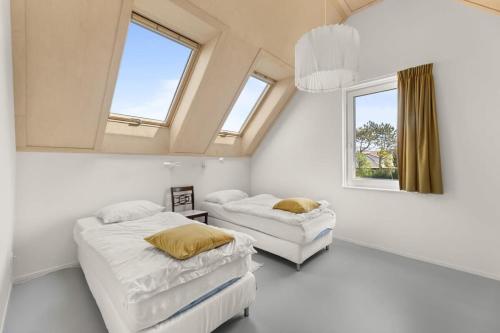 栋堡NEW Hello Zeeland - Vakantiehuis Jhr De Casembrootplein 19的一间卧室设有两张床和两个窗户。