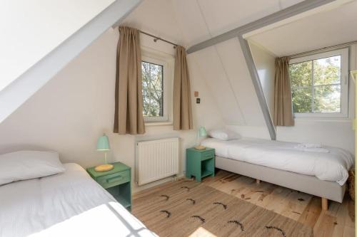韦斯特卡佩勒Het Kleine Huis at Buitenplaats Zeeuwse Liefde的一间卧室配有两张床和镜子