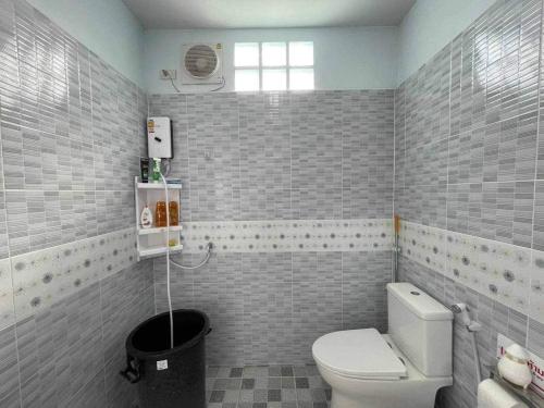 武里南Manee House - บ้านมณี的一间带白色卫生间的浴室和窗户。