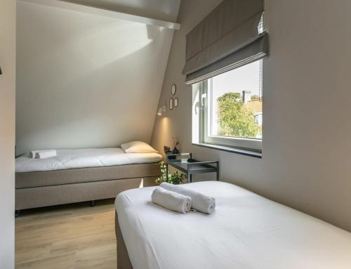 栋堡Hello Zeeland - Vakantiehuis Herenstraat 1A的一间小卧室,配有两张床和窗户