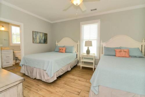 默特尔比奇Anchor Down Luxury Ocean View Beach House w Pool的一间卧室配有两张带蓝色和橙色枕头的床