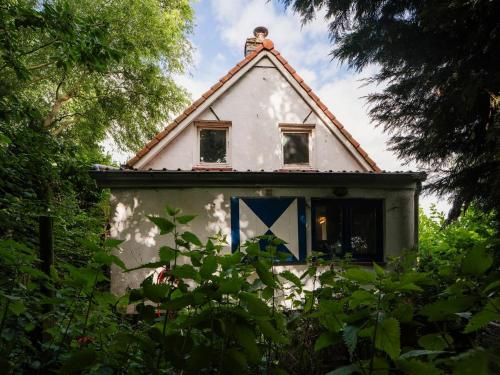 HengstdijkHello Zeeland - Vakantiewoning 't Schrijvershuisje的一间白色的小房子,有 ⁇ 帽屋顶