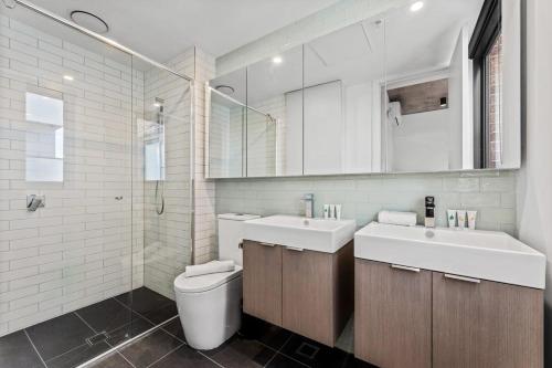 墨尔本Modern Chic Retreat - 2 BR Apartment Hawthorn的一间带卫生间、水槽和镜子的浴室