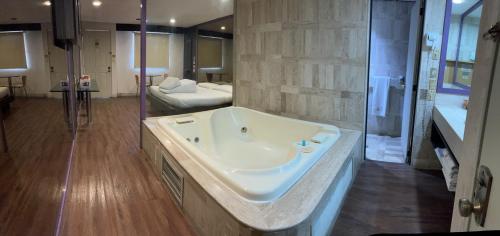 奥科约阿卡克Suites & Villas Real Hacienda的带浴缸的大浴室和卧室