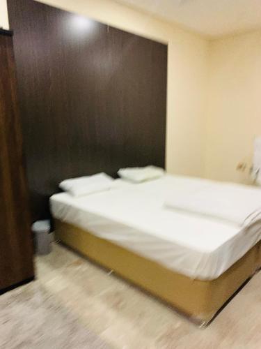 ‘Ūd al BayḑāʼArsaad villa apparments的一张带白色床单和枕头的床