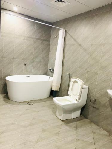 ‘Ūd al BayḑāʼArsaad villa apparments的带浴缸、卫生间和盥洗盆的浴室