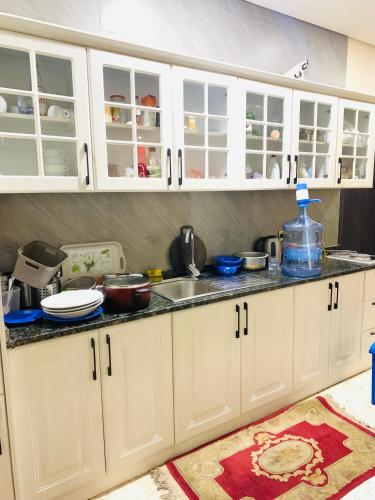 ‘Ūd al BayḑāʼArsaad villa apparments的厨房配有白色橱柜和水槽