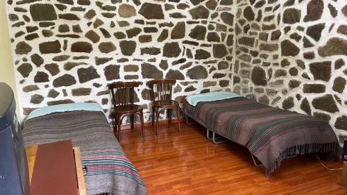 波格拉德茨Bitro House的一间设有两张床和石墙的房间