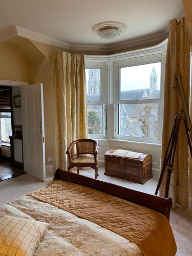 新罗斯Victorian Villa的卧室配有床、椅子和窗户。