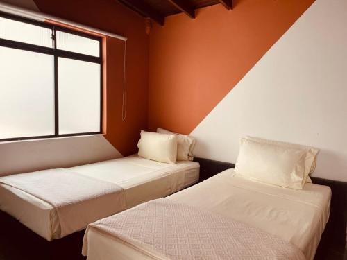 伊塔圭Chic Duplex Loft的带窗户的客房内的两张床