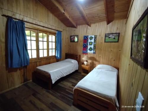 伊图萨因戈Wild Wetlands Lodge的小木屋内一间卧室,配有两张床