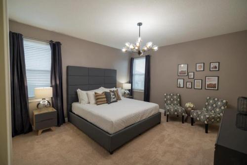奥兰多Stunning Luxury 9BR Encore Villa by Disney的一间卧室配有一张床、椅子和吊灯