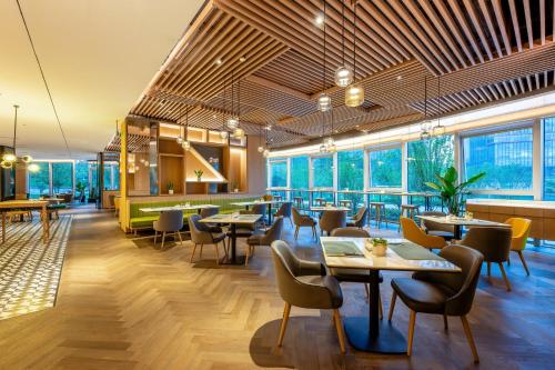 重庆重庆仙桃数据谷假日酒店的餐厅设有桌椅和窗户。