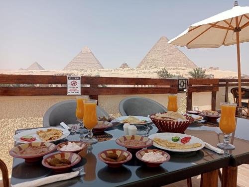 开罗Pyramids Era View的金字塔顶上一张有食物盘的桌子