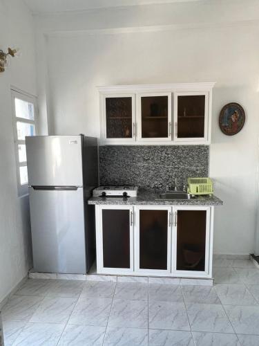 圣多明各YOUR SPACE COLONIAL的厨房配有白色橱柜和白色冰箱。