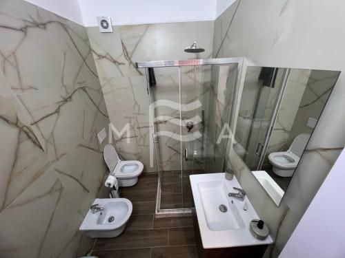 格勒姆Spacious Living 828的一间带两个盥洗盆、淋浴和两个卫生间的浴室