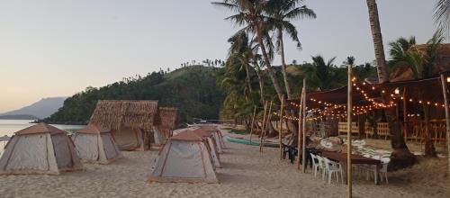 圣维森特Amwani Sunset Colours的海滩上一群有树木和水的帐篷