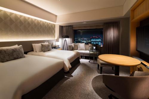 东京东急涩谷蓝塔大酒店的酒店客房设有两张床和一张桌子。