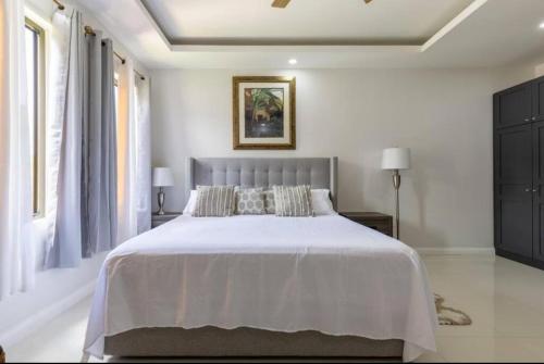 Old HarbourLuxury Palm的一间卧室配有一张带白色床单的大床