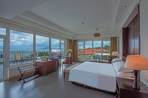 惠东惠州金海湾喜来登度假酒店的一间带一张白色大床的卧室和一个阳台