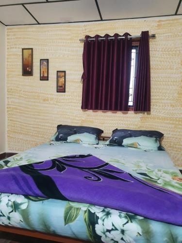 TalalaJadeshwarfarm&Resort的一张带紫色棉被和枕头的床