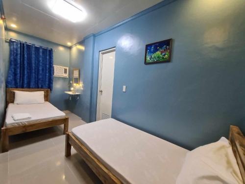 TubigonDrossgold Pension House的一间卧室设有两张床和蓝色的墙壁
