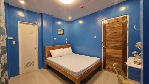 TubigonDrossgold Pension House的小房间设有床和蓝色的墙壁