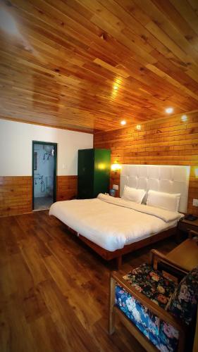 马拉里Highland Heritage cottages的木制天花板的客房内的一张大床