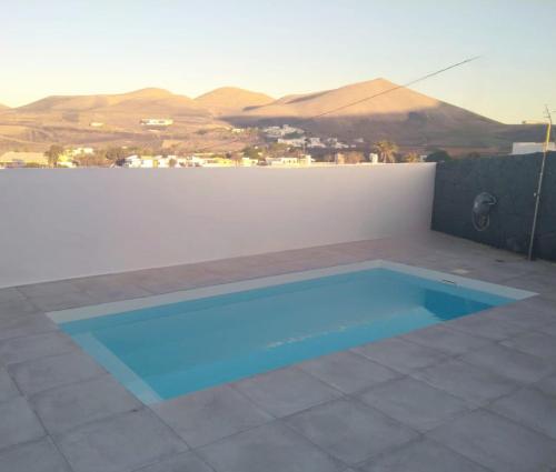 UgaTranquilidad entre volcanes的一座位于庭院内的游泳池,庭院内以群山为背景